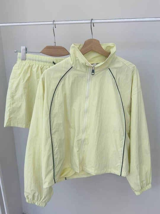 Damen gekürztes Windjacke-Set mit Stehkragen, kontrastierender Paspelierung und elastischer kurzer Freizeit-Hose Eichborn Berlin