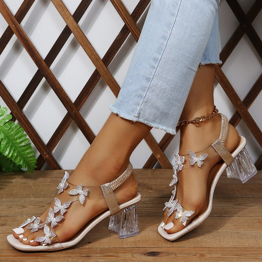 Damen Glamouröse Sandalen mit funkelnden Schmetterlingsdetails und transparentem Blockabsatz EB