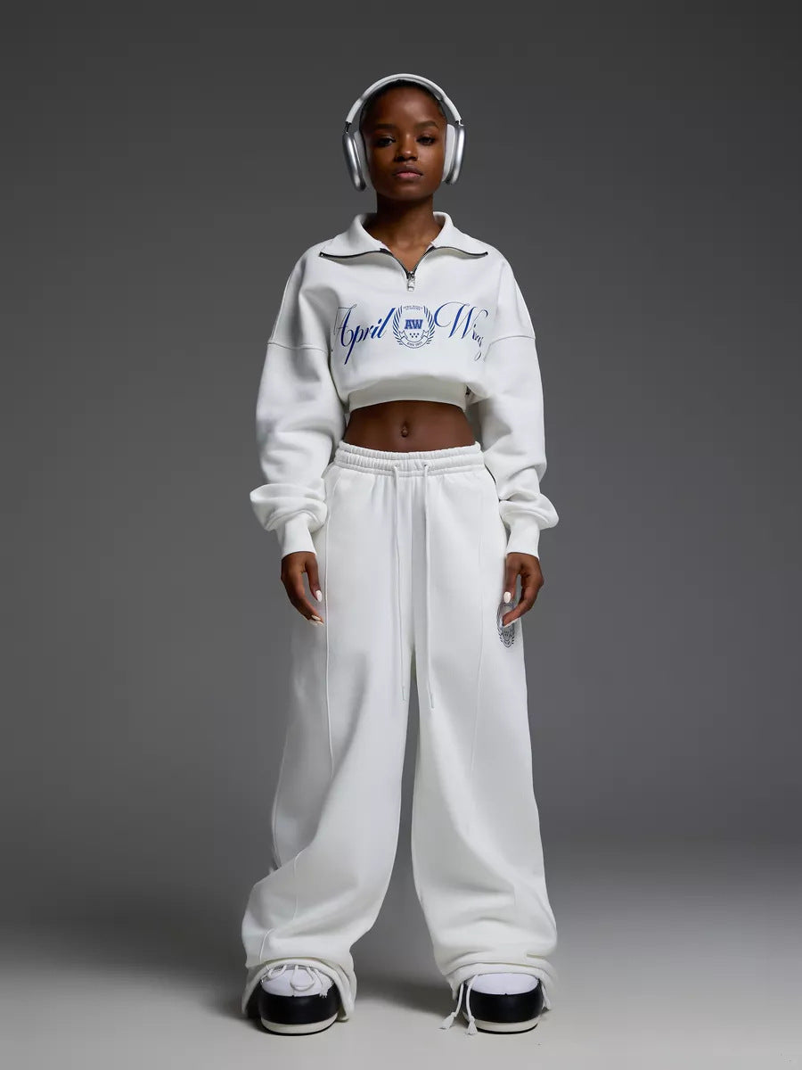 Damen gekürztes Halfzip-Sweatshirt mit Collegestickerei und weit geschnittene High‑Waist Lounge-Jogginghose Eichborn Berlin