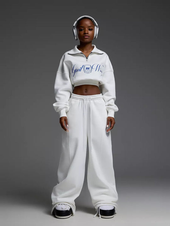 Damen gekürztes Halfzip-Sweatshirt mit Collegestickerei und weit geschnittene High‑Waist Lounge-Jogginghose Eichborn Berlin