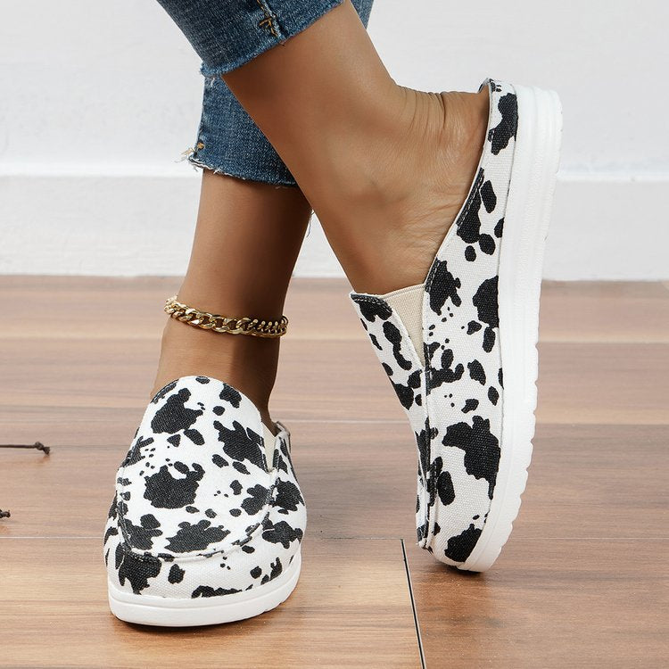 Damen  Slip-On Canvas‑Mules mit Kuhfleckenprint, gepolstertem Komfortfußbett und rutschfester Leichtsohle EB