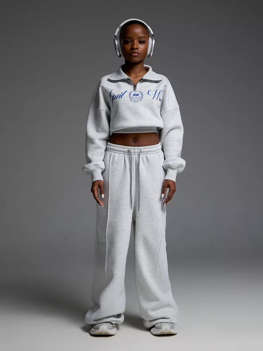 Damen gekürztes Halfzip-Sweatshirt mit Collegestickerei und weit geschnittene High‑Waist Lounge-Jogginghose Eichborn Berlin