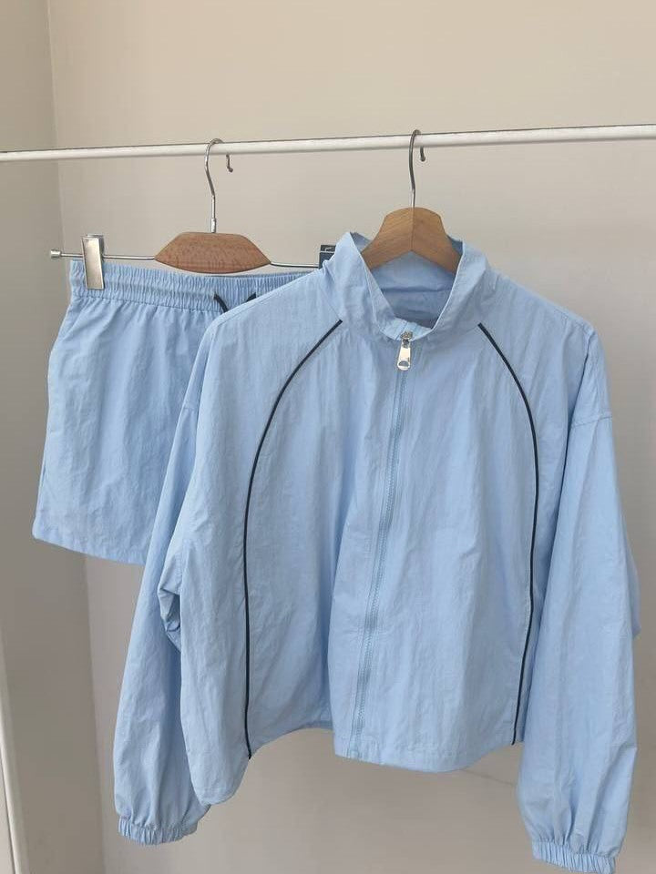 Damen gekürztes Windjacke-Set mit Stehkragen, kontrastierender Paspelierung und elastischer kurzer Freizeit-Hose Eichborn Berlin