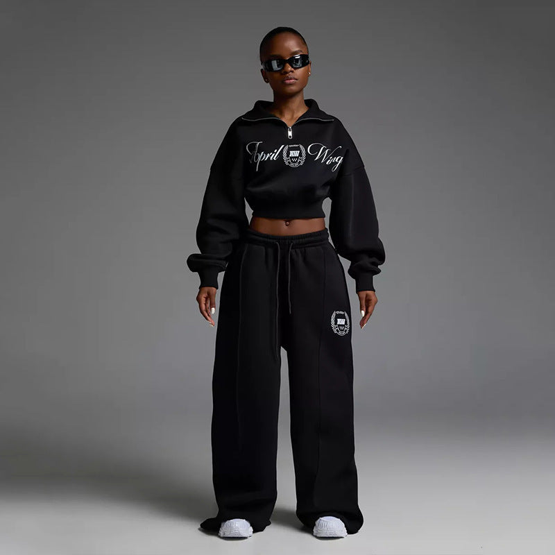 Damen gekürztes Halfzip-Sweatshirt mit Collegestickerei und weit geschnittene High‑Waist Lounge-Jogginghose Eichborn Berlin