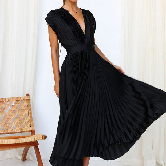 Model in einem schwarz kleid mit v-ausschnitt, elegant stehend vor einem minimalistischen hintergrund